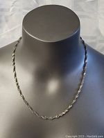 Full view of the sterling silver necklace displayed on a black mannequin, showing the full chain length and overall look.