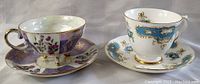 Two teacups with saucers side by side, showing full design and colors on both.