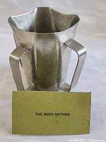 Front view of the pewter Irish Mether with label in front.