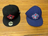 Two Toronto Blue Jays caps side by side showing front logos and flat brims
