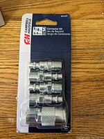 Photo shows five shiny chrome-plated connector fittings in blister packaging labeled Campbell Hausfeld 1/4 inch connector kit.