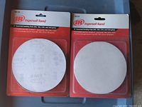 Two packages each containing 4 round sanding pads, 6 inches diameter, assorted grit, new in original packaging.