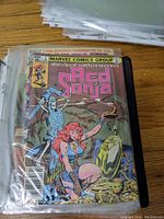 Front cover of the Marvel Comics Red Sonja comic book in its protective sleeve, showing detailed cover art and price.