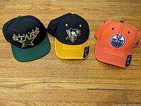 Front view of the three caps together showing logos and color scheme