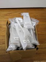 Box containing 29 individually packaged Top Knobs cabinet pulls from the Stainless II series