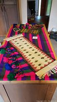 Overview of brightly colored wrap beside wool mat on countertop.