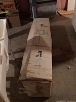 Full view of the original packaging box showing the condition and size of the boxed tree, stored in basement environment.