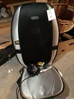Full view of the Homedics massaging seat cushion with power cord and control device on the seat part.