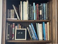 Bookshelf with assorted used hardcover and softcover books, showing titles and varied subject matter.