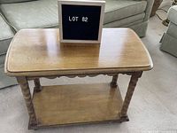 Top view of the side table showing wood grain, gentle wear marks, and LOT 82 sign.