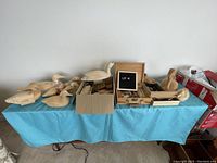 Photo showing entire woodworking carving lot with multiple wooden duck decoys on left, cardboard box in center, and wooden tool cases to the right on a blue cloth.