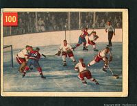 Front of 1954-55 Parkhurst hockey card #100 showing hockey scene with goalie Sawchuk blocking a shot and several players on ice.