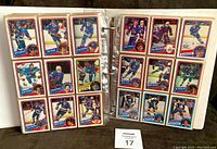 Two binder pages with 1984-85 O.P.C. hockey cards showing players in action, organized in 9 card slots per page.