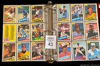 Binder open showing multiple 1985 O.P.C. baseball cards featuring players from multiple MLB teams in plastic pages.