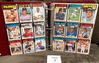 Open binder pages showing multiple team cards including Padres, Mets, Giants, Cubs, Tigers, Brewers, Mariners, White Sox, Yankees, Blue Jays, Rangers, Phillies, Red Sox.