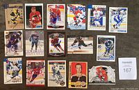 Top view of 16 autographed NHL hockey cards laid out in four rows showing signatures in Sharpie.