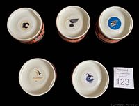 Bottom view of each puck showing the corresponding team logo and original official NHL Centre Ice game puck packaging.