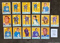 Top side view of 16 Toronto Maple Leafs hockey cards from 1970-71 OPC set arranged on table. Cards feature various Leafs players including Jacques Plante, Dave Keon, Paul Henderson, Ron Ellis. Most cards have colored backgrounds and display players in action or portrait poses.