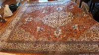 Full view of rectangular rug laid on wood floor showing central medallion and border