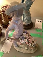 Front left angle view of the figurine showing girl and flower-filled wheelbarrow