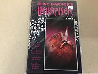 Front cover of the Hellraiser comic depicting skull motifs and a hand stabbed with a knife.