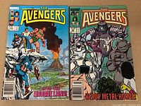 Two Avengers comics side by side on a flat surface, titles visible, colorful covers with characters and story names.