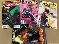 Photo showing all four Batgirl comics with visible issue numbers and cover art