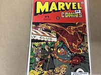 Photo of the front cover of Marvel Mystery Comics #1 in a protective plastic sleeve showing classic comic characters and bright cover colors.