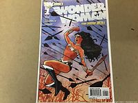 Front cover of Wonder Woman #1 comic book featuring Wonder Woman holding a sword and lasso against a dark background.