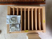 Two wooden foldable dog/child gates side by side in folded form with mounting hardware on top