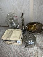Overview photo of all kitchen and serving items showing colanders, teapot, manual press, and fabric bag.