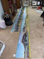 Two long landscape paintings on the floor side by side with a measuring tape showing approximately 31 feet combined length.