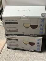 Two unopened boxes of Luigi Bormioli Symphony wine glasses showing packaging and branding.