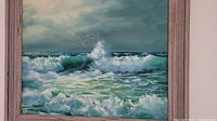 Full view of framed ocean painting showing waves and seagulls under cloudy sky.