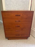 Front view of teak dresser showing four integrated flush drawer pulls and plinth base