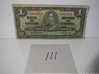 Front view of 1937 Bank of Canada one dollar bill showing portrait of King George VI, serial number, and signatures.
