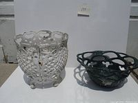 Front perspective view of white and green cast aluminum planters showing decorative openwork design and overall shape