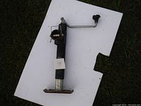 Full view of the black metal trailer jack showing the crank handle, mounting plate, and body.