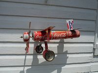 Side profile photo of the handmade airplane wind spinner crafted from Coca Cola cans showing the side and propeller.