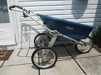 Side view of the wheelbarrow showing large air tires, metal frame, and blue plastic tub with Jackson branding.