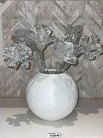 Clear glass flowers arranged in a white vase on a countertop, showing overall arrangement and size.
