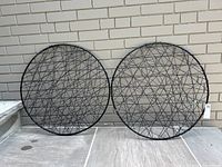 Two black metal wire hanging sculptures placed next to each other, showing front view.