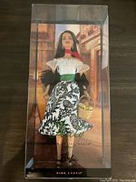 Full view of Barbie doll in original plastic box showing full outfit and basket accessory.