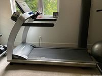 Side view of treadmill showing frame, belt and console