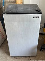 Full front view of the Magic Chef mini fridge showing the silver finish with the black trim.