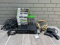 Front angle showing consoles, game stacks, headset, controllers and cables