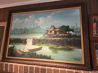 Large oil painting of a traditional Manila riverside scene with boats and houses, signed B.P. Pasano, dated 1971, hanging above a brick wall.