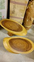 Two teak slab stump end tables shown from top view revealing oval polished slabs and the natural wood grain on top surfaces.