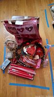 Photo showing all Valentine-themed items including tray, banner, red candles, heart-shaped boxes, glass heart-shaped glasses, music box with soap, and glass candle holder on a wooden floor.