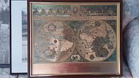 Framed map print showing dual hemispheres of world map and decorative elements.